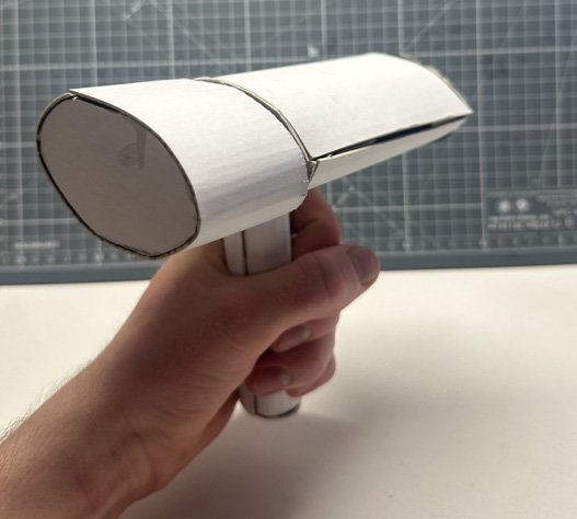 Hand holding a card prototype of the steamer